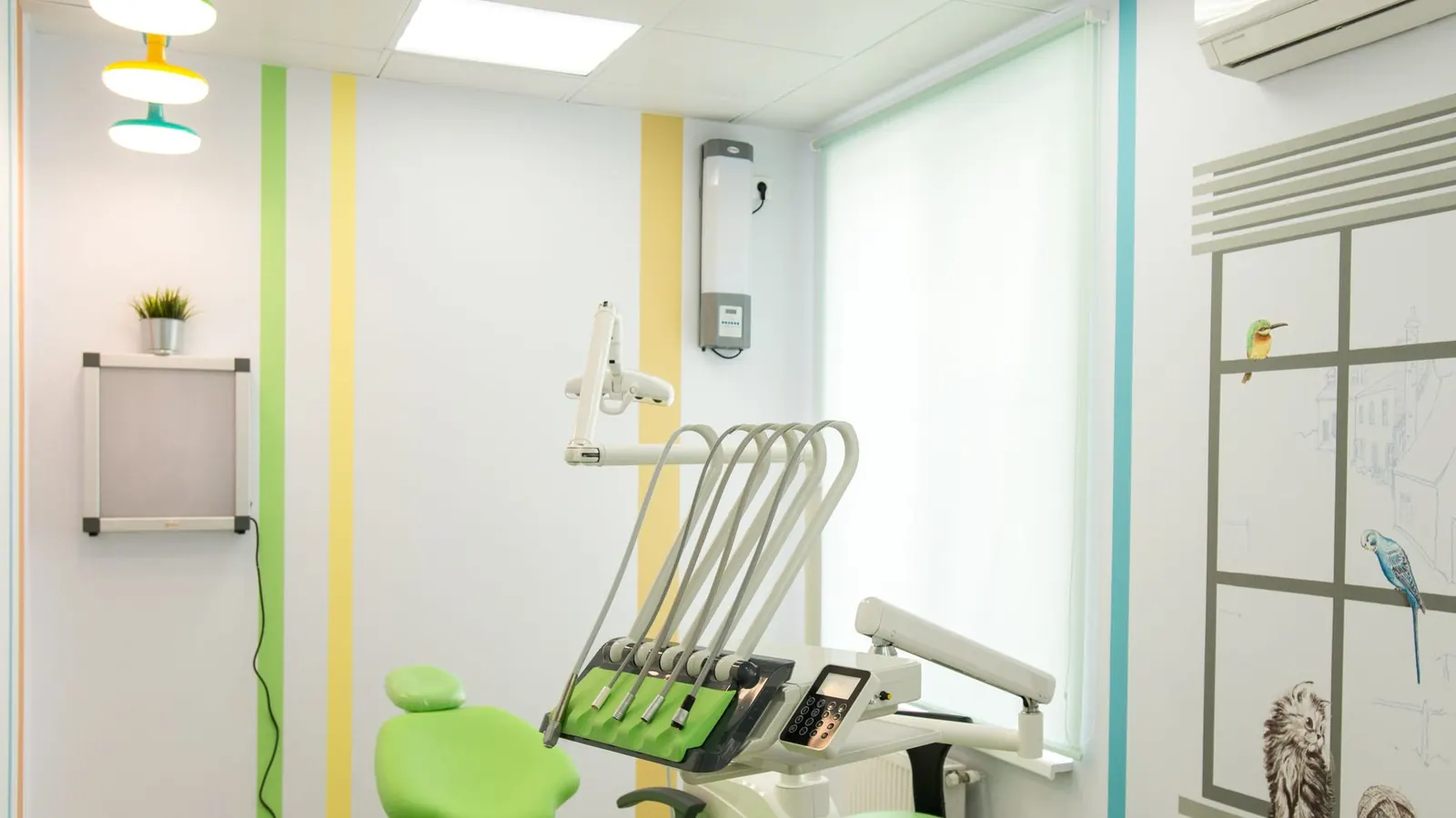 Consultório dentário vazio, com cadeira, equipamento e uma unidade de ar condicionado na parede